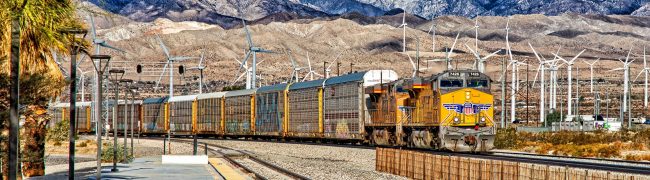 Palm Springs, California, USA - January 23, 2021: Union Pacific Freight train and Wind Turbine at Palm Springs Amtrak Station (PSN).